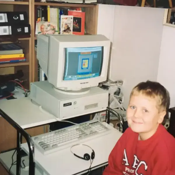 Owain as a young boy sitting beside his first Packard Bell Legend computer