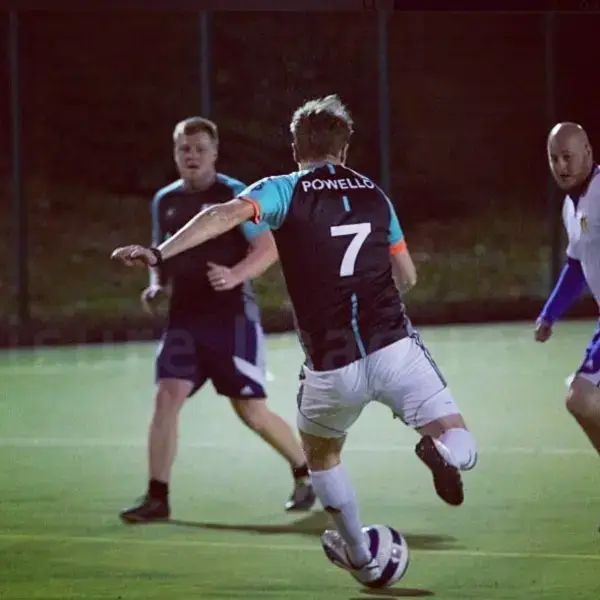 Owain striking the ball in a number 7 Powello shirt at five-a-side