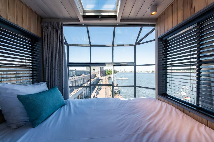 The YAYS Crane Apartment bedroom in Amsterdam, looking out over the harbour