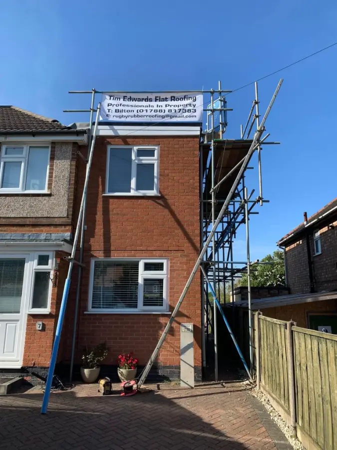 Scaffolding with a Tim Edwards Flat Roofing banner