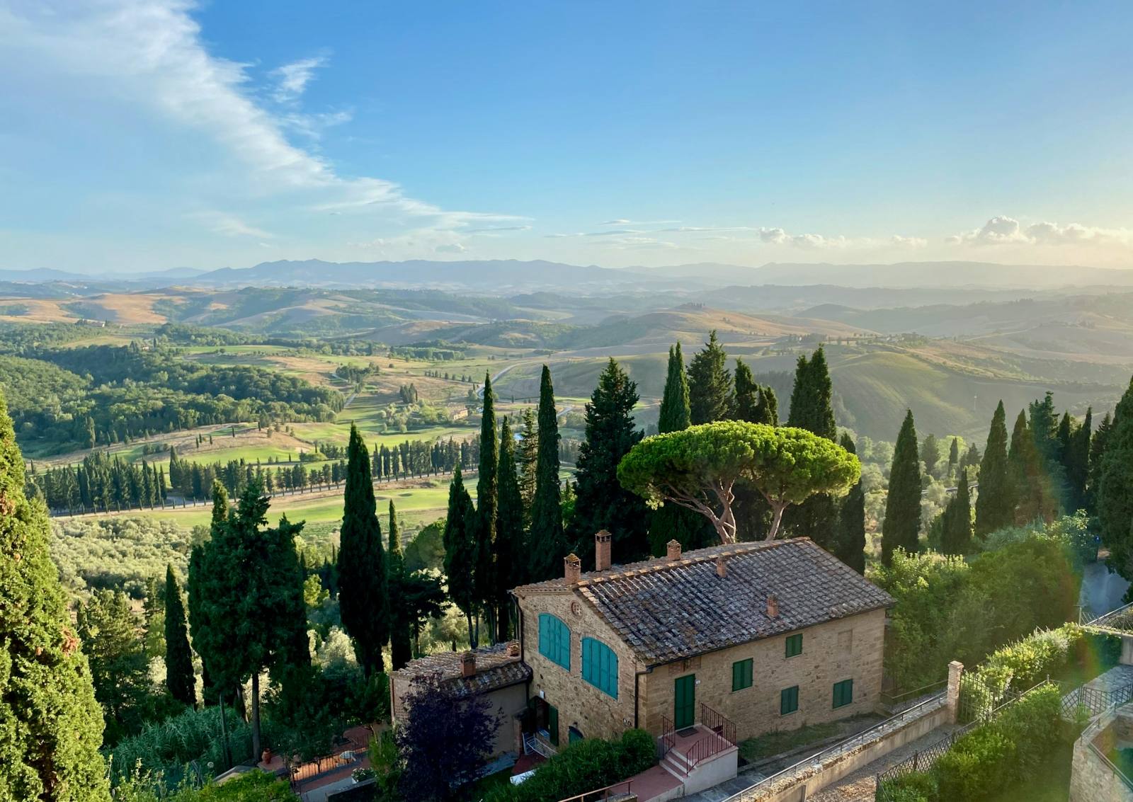 A stone villa among cypress trees above the Tuscan hills